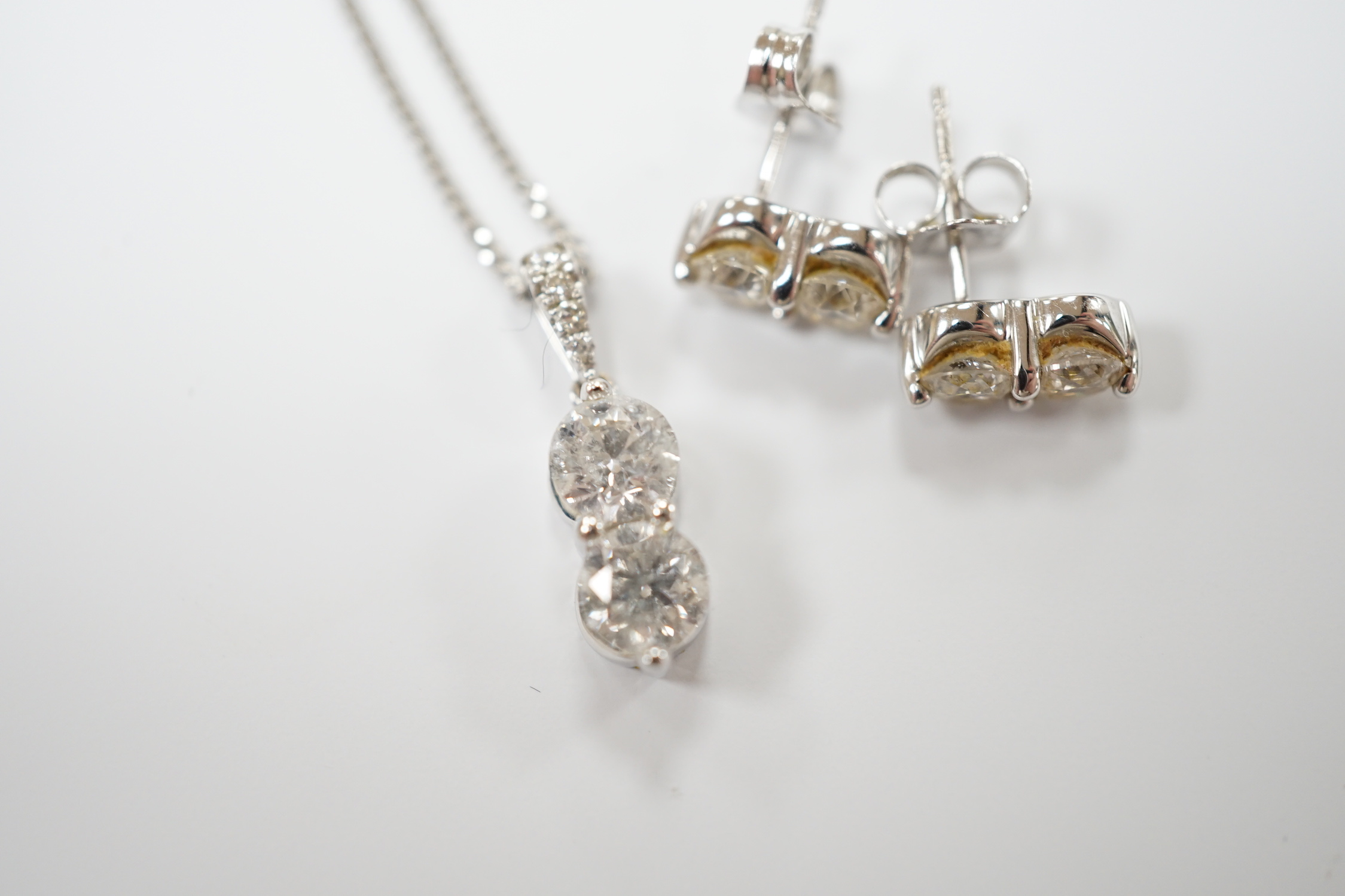 A modern 14k gold and two stone diamond set pendant, with diamond chip set bale, on a 14k gold fine link chain